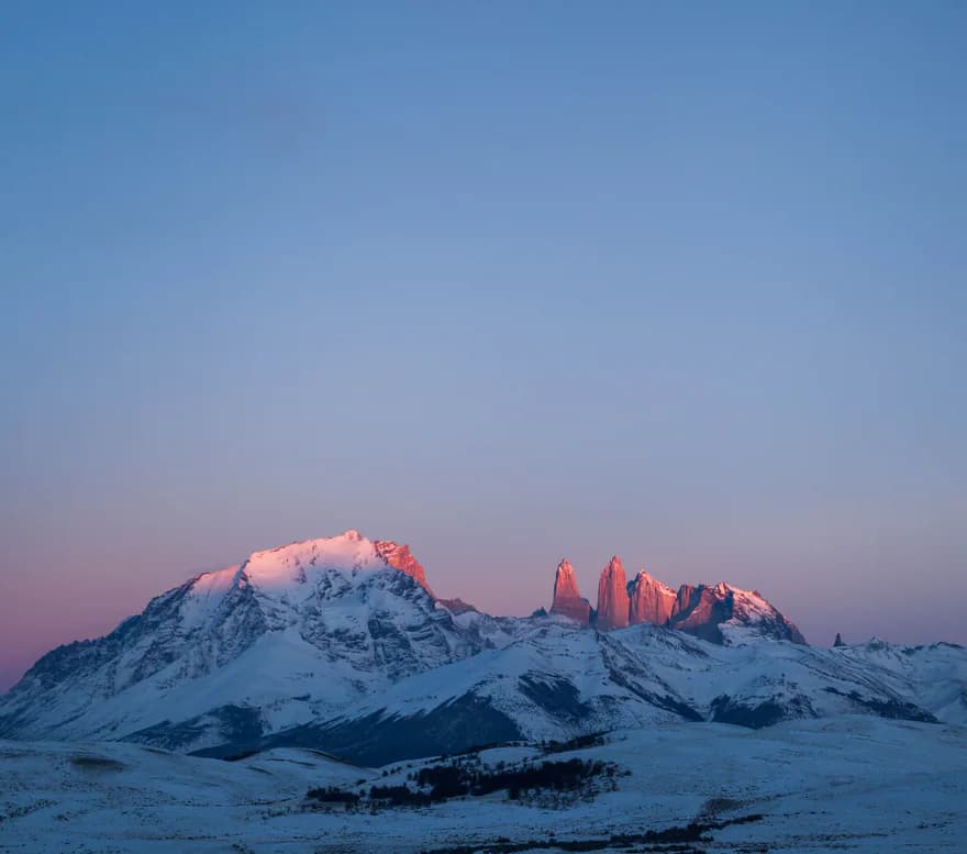 A snow-capped peak catching the first pink light
