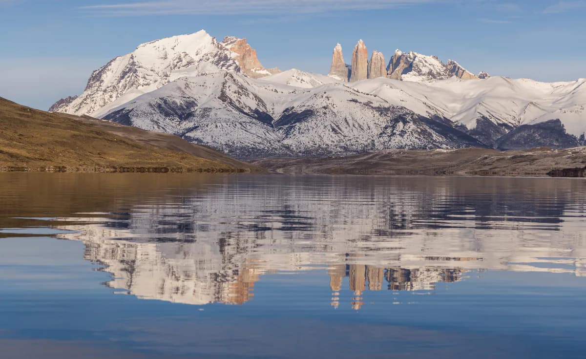 Snowy mountains and the towers mirrored in a calm lake