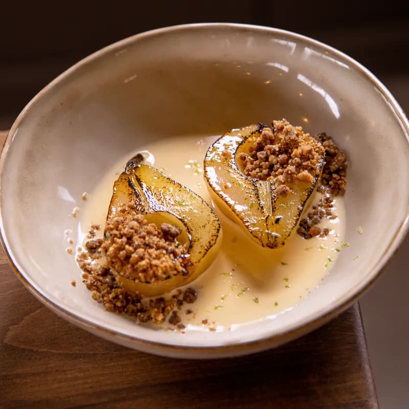 Poached pears with crumble in a cream sauce