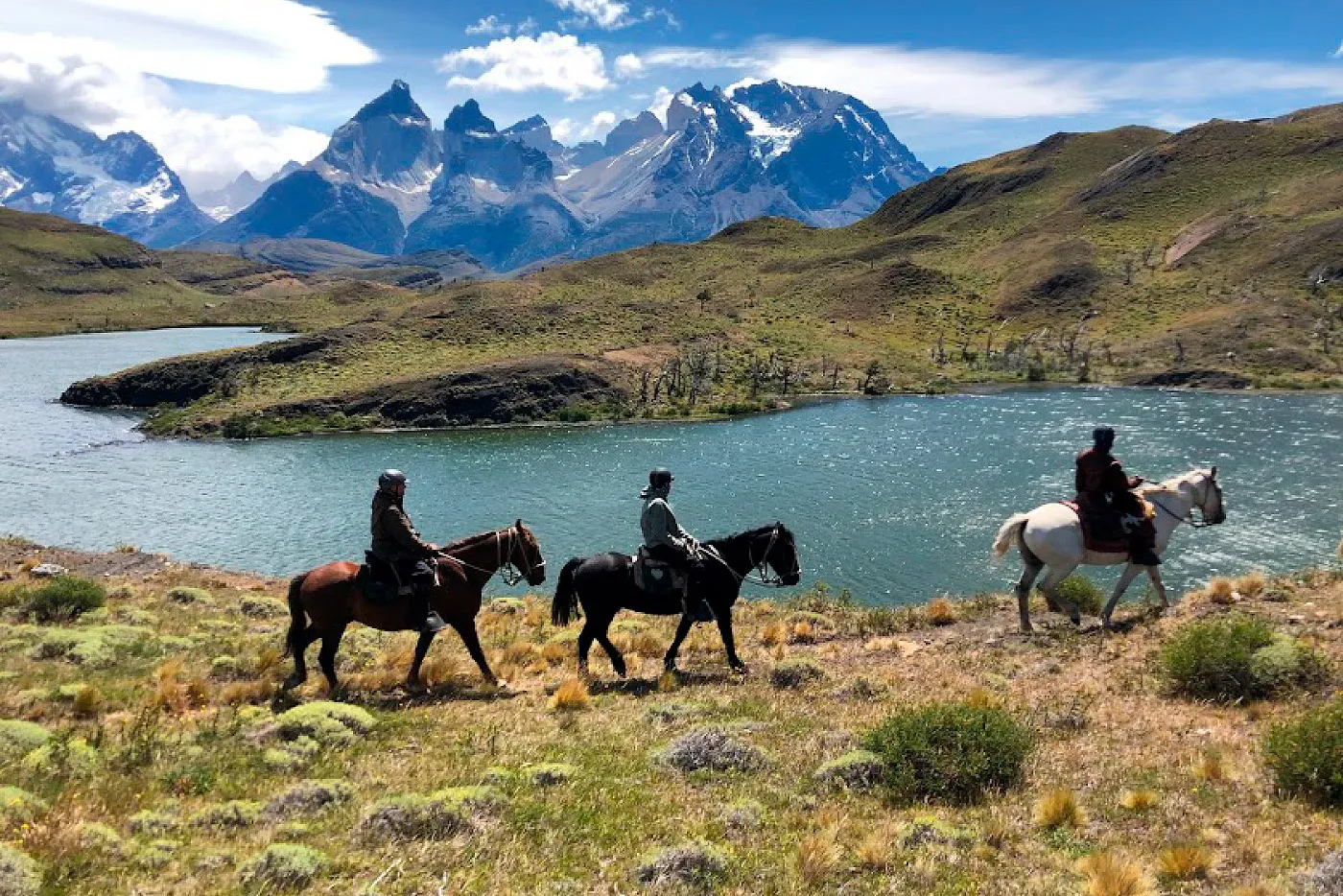 Horseback riding beside a lake in Torres del Paine